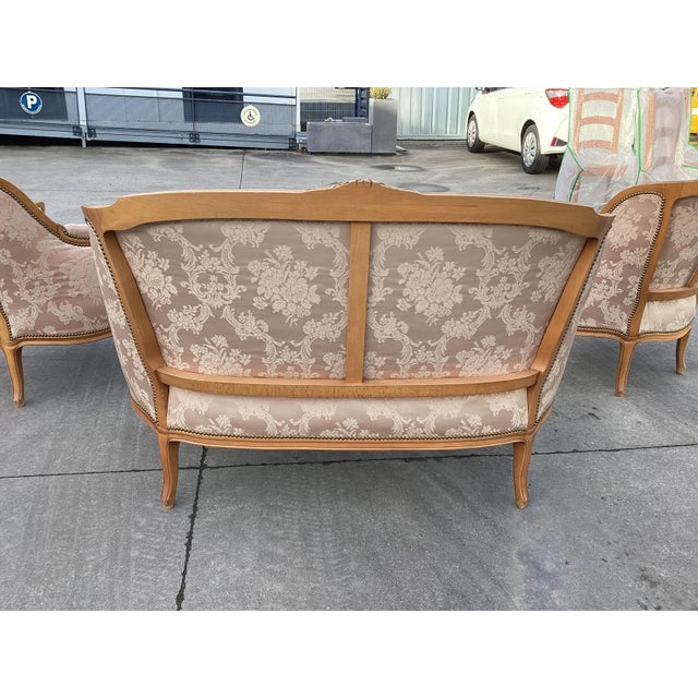 Elegant French settee with pink silk upholstery. Circa 1920, this settee is made of natural, light fruitwood and features...