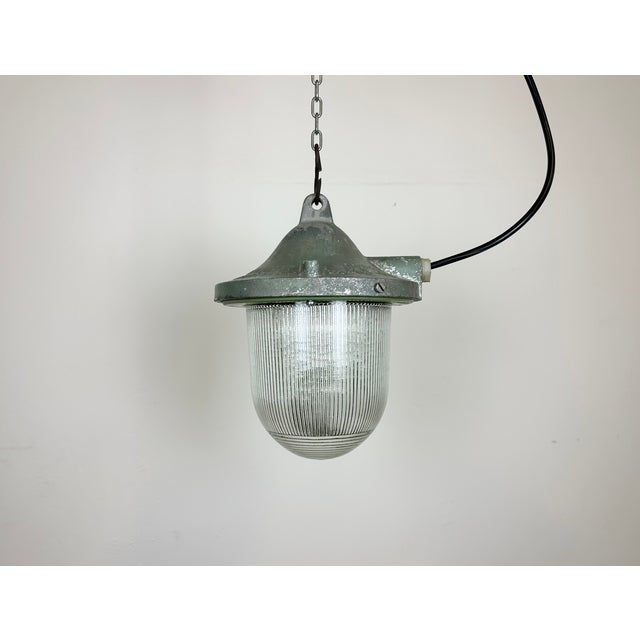 Green industrial lamp made by Polam Gdansk in Poland during the 1960s. It features a cast aluminium body and a striped...