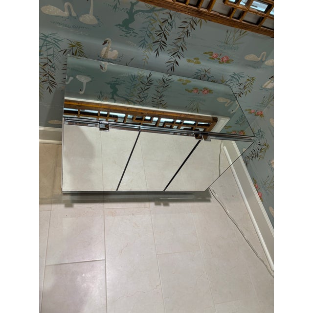 Gorgeous & versatile mirror and chrome credenza by Ello. Three doors, enclosing two cabinet spaces with one adjustable...