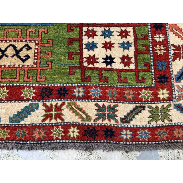 Caucasian Fachralo Kazak design hand-knotted rug featuring a commanding ivory octagonal medallion with a navy blue center,...