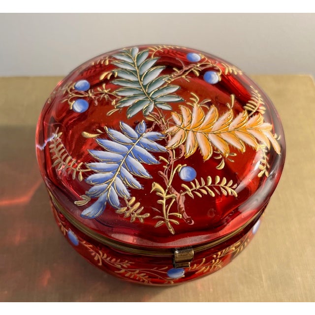 Antique round cranberry glass trinket box/dresser box with multi color enamel hand painting with gold accents. Intricate...
