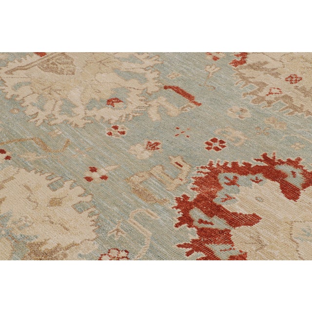 This 12x15 rug from the Modern Classics Collection features a sky blue field, beige borders and rich red tones along with...