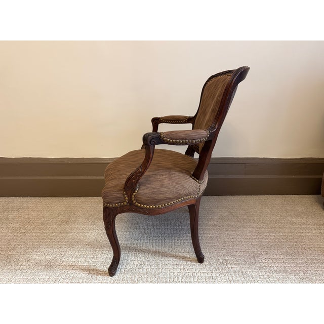 Elegant Louis XV–style provincial armchair (fauteuil) crafted in walnut, featuring a softly shaped upholstered back,...