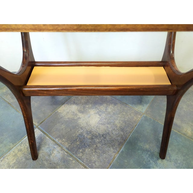 This coffee table is attributed to Cassina for form and style. No mark and label. Original glass shelf. Storage...