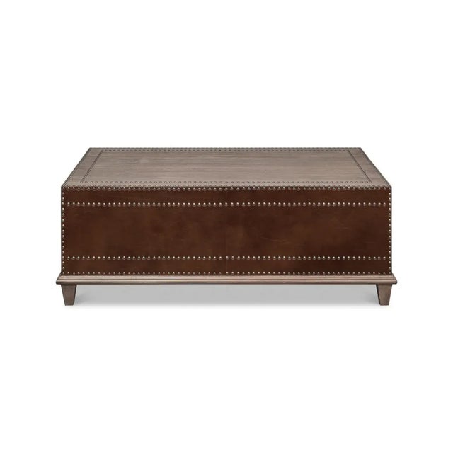 A classic equestrian-inspired coffee table with brown leather-wrapped sides. With hand-placed nailhead accents and two...