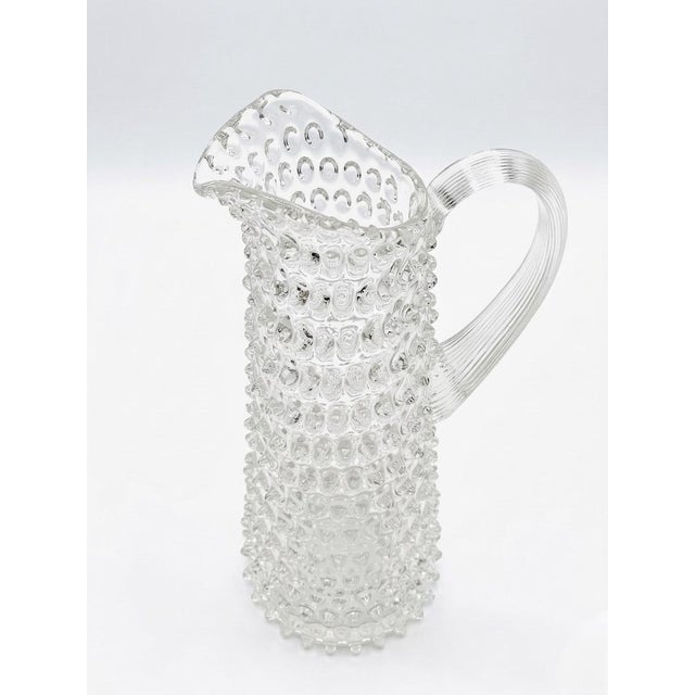 Elevate your bar cart or dining table with this stunning vintage clear glass pitcher. Featuring a bold, all-over hobnail...