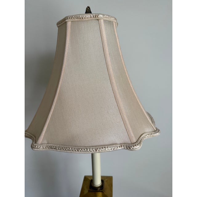 A pair of elegant, vintage-style table lamps. Each lamp features a tall, slender design with a cream-colored, slightly...