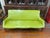 Striking mid-century modern sofa featuring a sculptural walnut frame, tapered legs, and organically curved seat in classic...