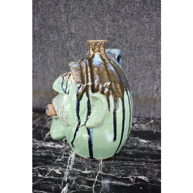 Whimsical terra-cotta glazed face jug.