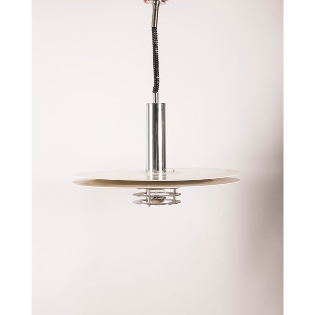 A Scandinavian ceiling lamp with a Space Age aesthetic, crafted in the 1970s from lacquered and chromed metal. The piece...