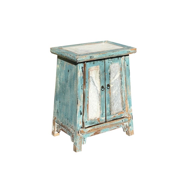 This rustic cabinet exudes a weathered, vintage charm with its faded turquoise finish, showcasing the natural wear and...