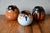 These three small, round, red-orange terracotta vases evoke something instinctive and warm, reminiscent of village pottery...