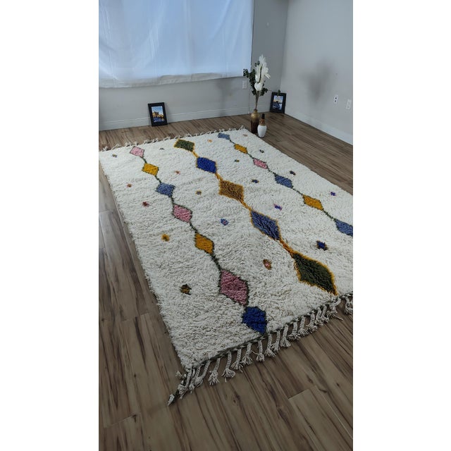 One-of-a-kind handwoven Azilal rug from the Atlas Mountains of Morocco. An ivory ground with a diagonal chain of diamonds...