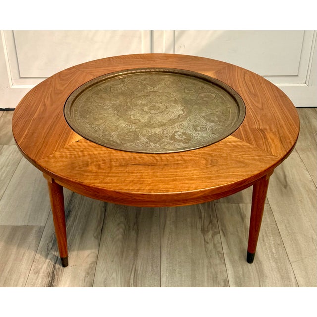Here is a fabulous, Mid-Century Modern round coffee table featuring a beautifully bookmatched wood veneer top surrounding...