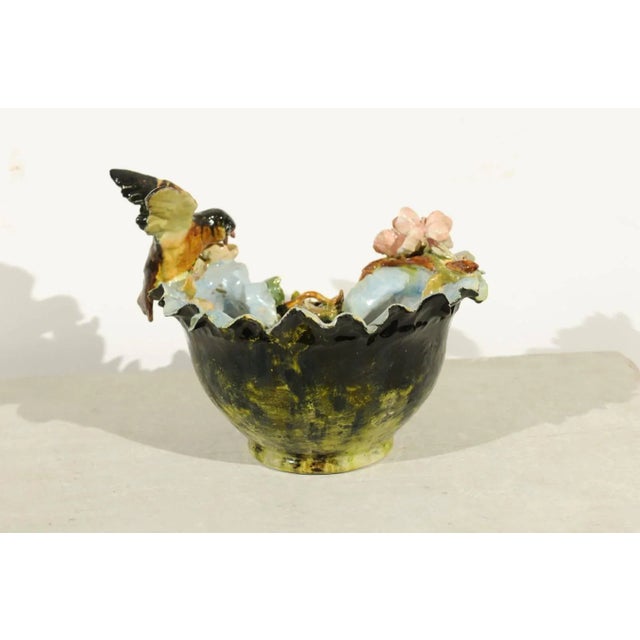 A 19th century petite French faience bowl adorned with a bird and bird nest barbotine décor. This French pottery features...