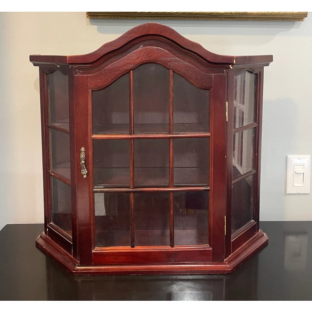 This vintage adorable cabinet is the perfect size to display your keepsakes. The piece is made of cherry finish wood. It...