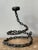 Inject a dose of raw, industrial edge into your decor with this striking vintage Brutalist snake sculpture. Hand-crafted...
