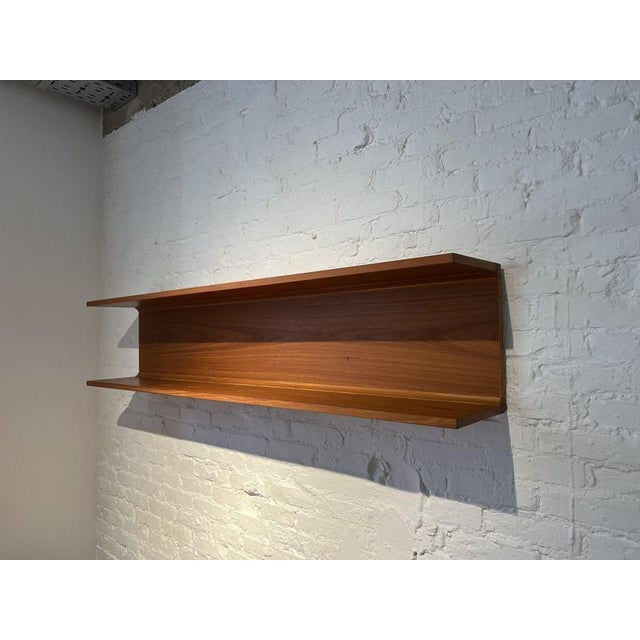A modernist wall shelf in teak wood manufactured by Pedersen & Hansen in Denmark around 1960. It is easy to hang using...