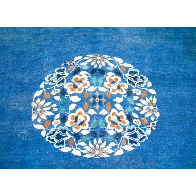 A wonderful late 19th century Chinese Peking rug with a round peony, chrysanthemum, and cherry blossom medallion set...
