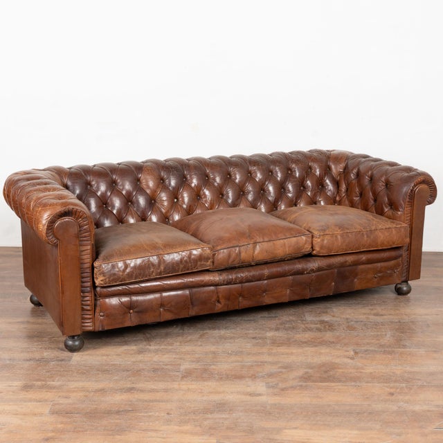 Set of three vintage brown leather Chesterfield seating group consisting of one three seat sofa and one pair of club...