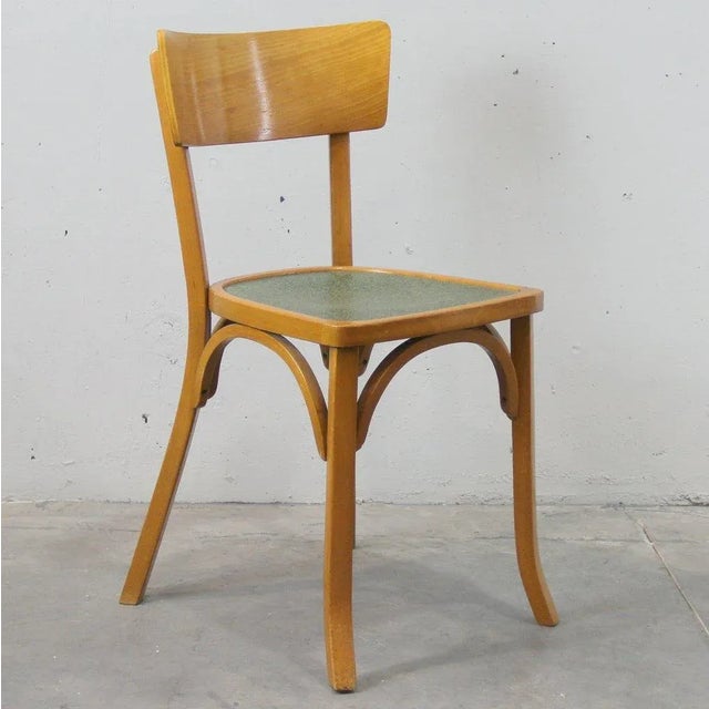 This set of four chairs is made of beech with seats patterned in green tones.