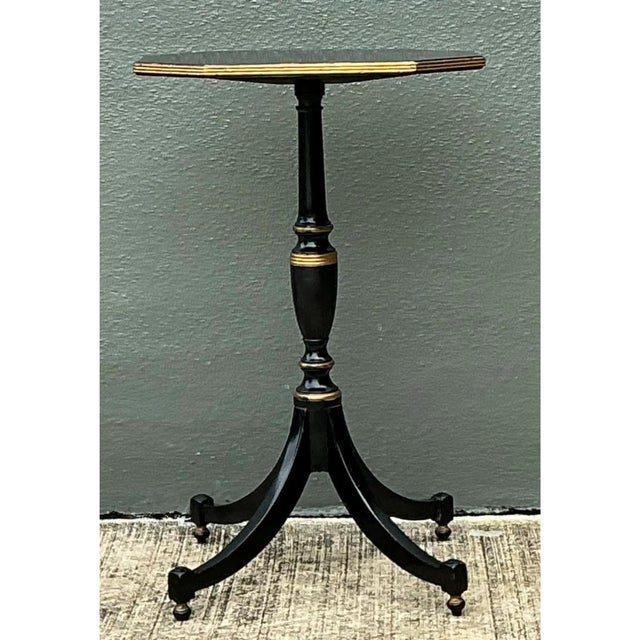 This vintage black and gold pedestal table presents an elegant octagonal top finished in glossy black lacquer with a...