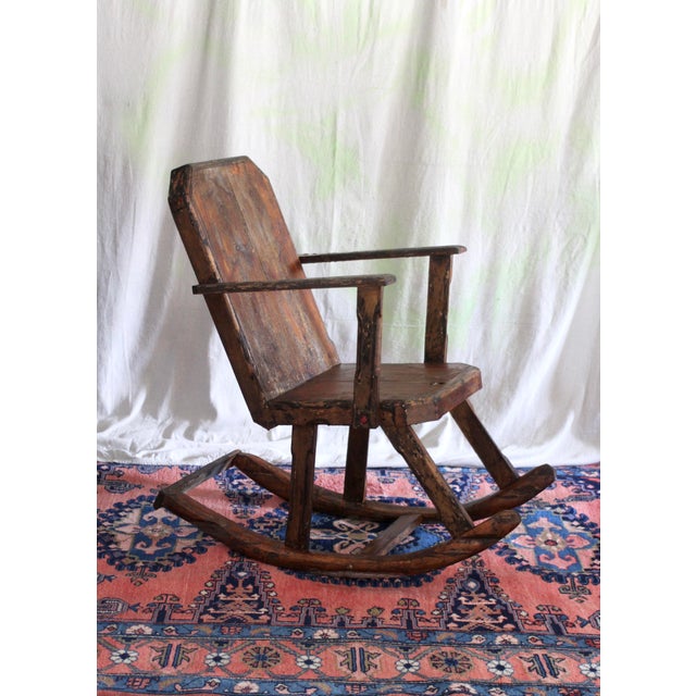 A wonderful rocking chair with handcarved details. Rustic wood planks and carved runners. A combination of plank and...