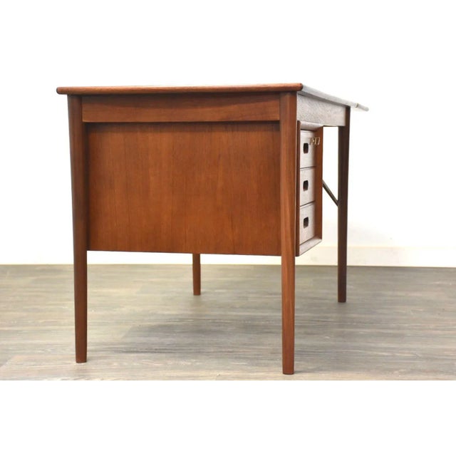 A mid century modern teak desk with a removable extension leaf designed by Erik Buch for O.D. Møbler. Fully extends to...
