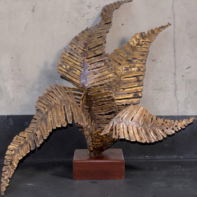This is a large mid-century modern brutalist brass fern sculpture on a wood base. It appears to be a very nice torch cut...