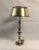 A striking brass bouillotte table lamp. The vintage library lamp has a brushed brass base with a bouillotte shade and...