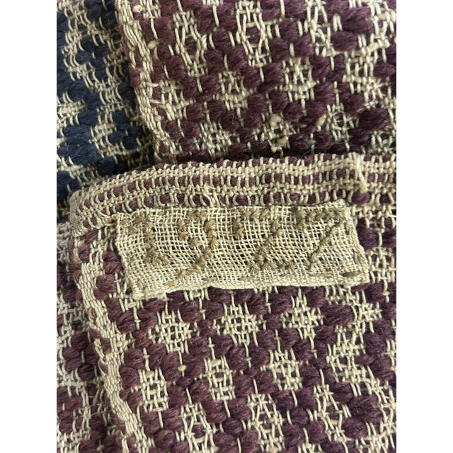 This twin bed overshot coverlet has a blue and purple woven pattern. Hand woven tag reads 1927. It seems the blue was used...