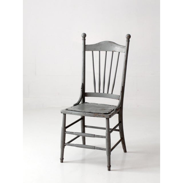 An antique spindle-back chair dating to circa 1890s–1910s, with a tall, graceful silhouette, slender turned spindles, ball...