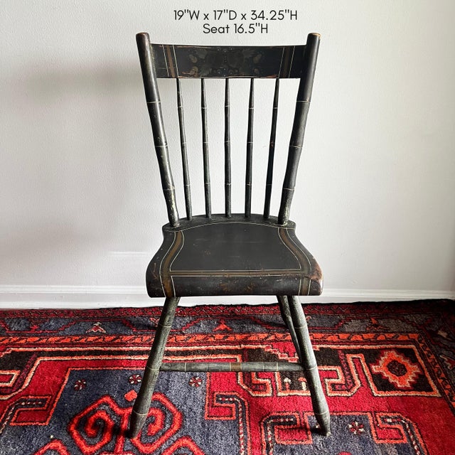 Antique Windsor side chair featuring a hand-painted black finish with delicate gold striping and faux bamboo detailing....