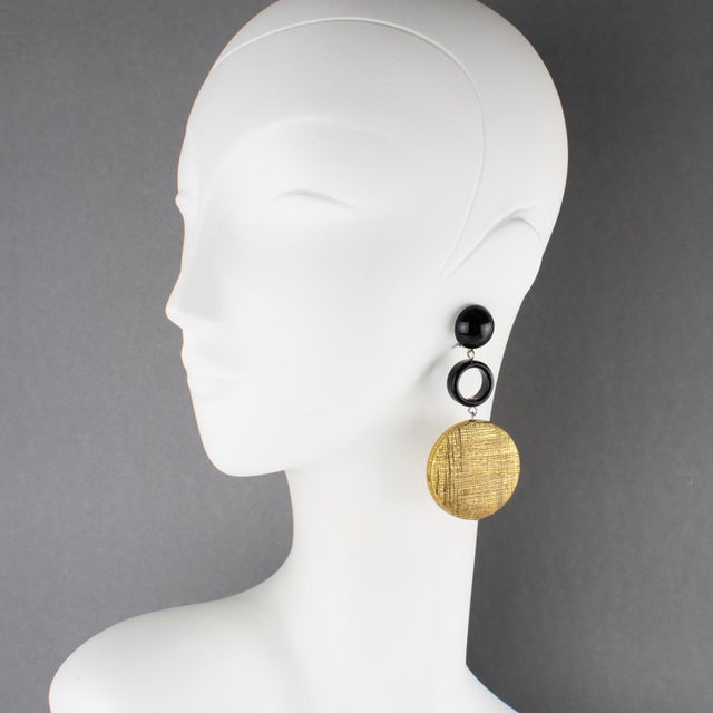 These stunning Angela Caputi, made in Italy, resin and metal clip-on earrings feature a dangling shape with black resin...