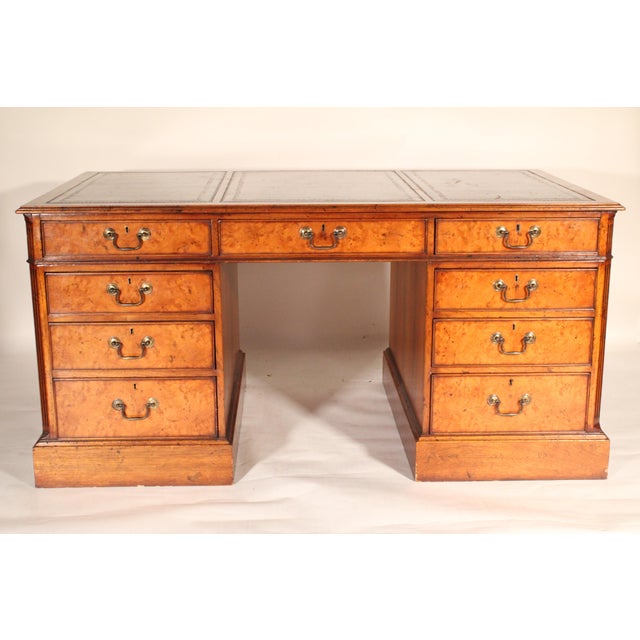 George II style burl elm and walnut double pedestal desk, circa 1920-1940. With a rectangular top with molded edges and 3...