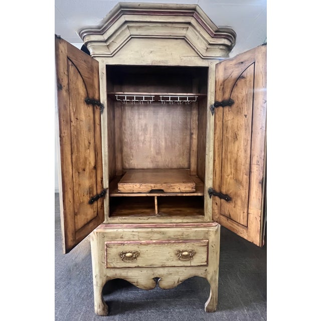This monumental Old World armoire is a true statement piece, crafted entirely of solid wood with incredible architectural...