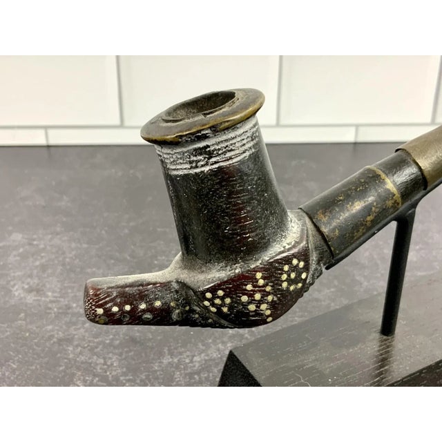 An early 20th century gracefully crafted African pipe from the Dinka tribe on a custom iron and wood stand. The Dinka are...