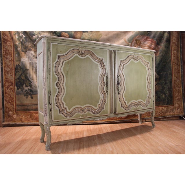 Carved wood cabinet with green re-lacquering, opening with two leaves carved with fretwork reserves, fluted uprights,...