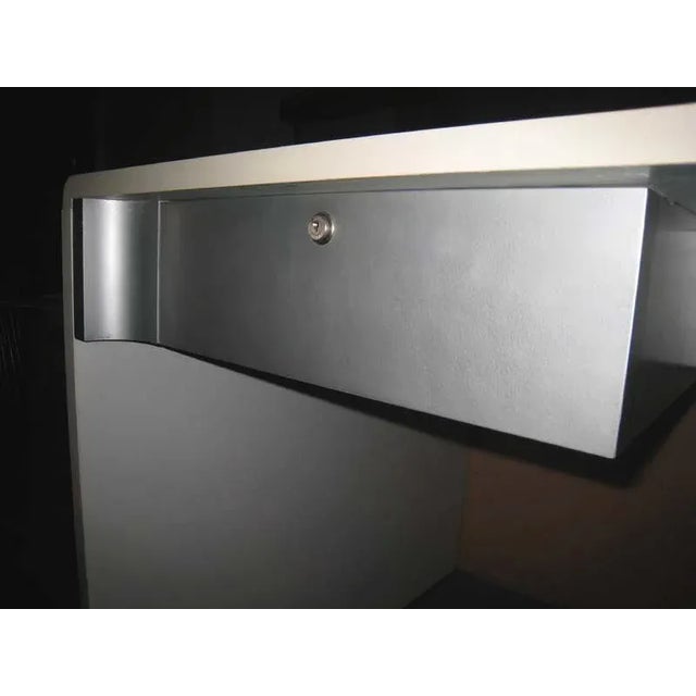 A white laminate and brushed steel desk.