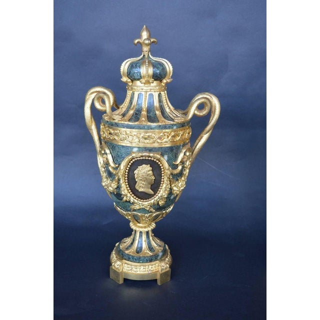 An elegant and highly decorative pair of late 19th century French green marble urns, distinguished by exceptional quality...