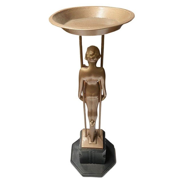 Frankart company figural “Sarcophagus Girl“ metal ashtray stand featuring a nude women holding up the ashtray stand...
