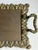 This vintage Victorian-style brass vanity tray features ornate detailing and decorative claw feet with a warm aged brass...