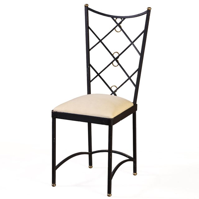A refined set of 2 French chairs, circa 1950, crafted in wrought iron with brass accents and designed in the elegant...