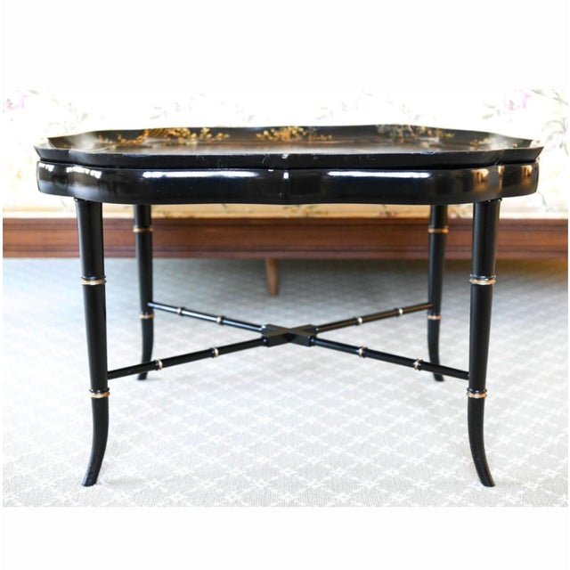 A beautifully crafted vintage lacquer tray table featuring a removable hand-painted chinoiserie tray with elegant...