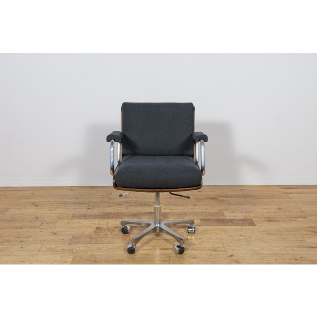 This swivel office chair, designed by Gordon Russell, was manufactured in the UK in the 1970s. The teak wood components...