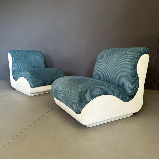 Set of two seventies armchairs, Italian manufacturing. The armchairs have a white fiberglass structure with a blue ribbed...