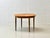 An elegant, round cherry wood dining table that impresses with its fine veneer work and balanced proportions. The tabletop...