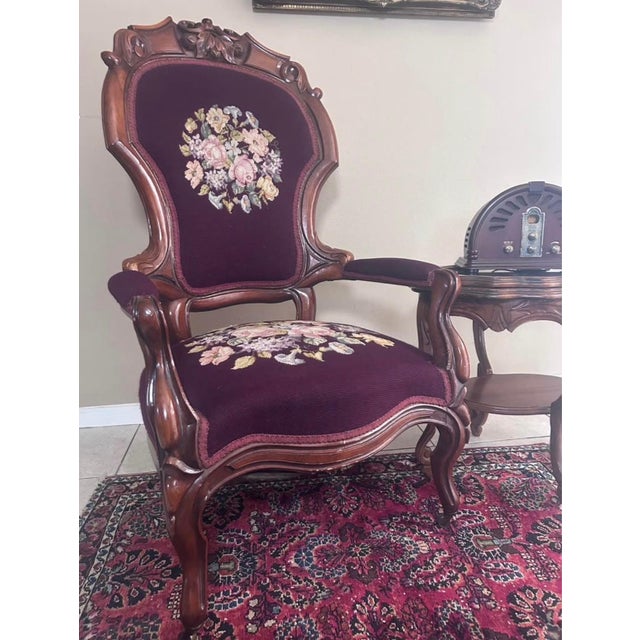 An elegant Victorian Rococo Revival armchair featuring a beautifully carved walnut frame with scrolling foliate details, a...