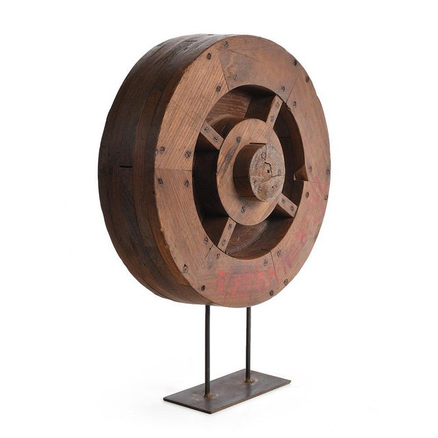 wooden wheel disposed on a foot of iron. This piece is designed in the style of the selected designer and/or manufacturer