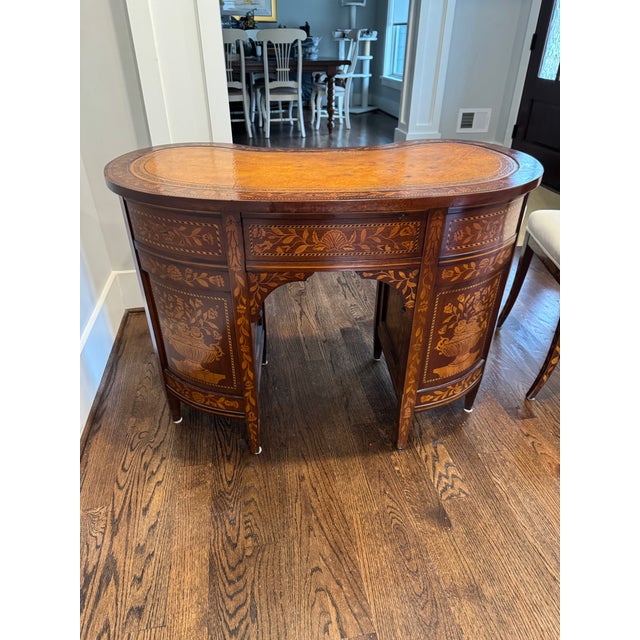 The shaped kidney-form top above a central kneehole, flanked by graduated drawers and curved cupboard sections, the whole...